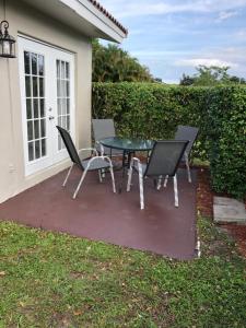 un patio con tavolo e sedie di fronte a una casa di Coral Springs Paradise a Coral Springs