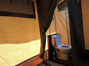 a toilet in a room with a tent at Serengeti Savannah Camps in Soronera