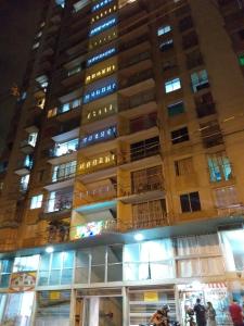 wysoki budynek w nocy z ludźmi przed nim w obiekcie CENTRO! San Lorenzo - Downtown - Apto con 2 Hab & Parqueadero w mieście Medellín
