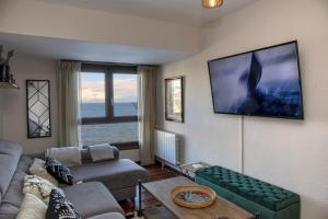 sala de estar con sofá y TV de pantalla plana en Sea Coast Lekeitio by HomeBilbao, en Lekeitio