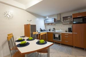 a kitchen with a table with green dishes on it at Apartmán Tatran Donovaly Deluxe in Donovaly