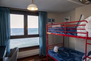 1 dormitorio con 2 literas y ventana en Sea Coast Lekeitio by HomeBilbao, en Lekeitio