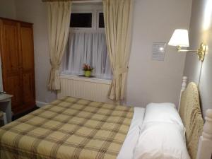 A bed or beds in a room at Chadwick House Hotel