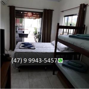 sypialnia z 2 łóżkami piętrowymi i oknem w obiekcie Suites Vista Do Parque w mieście Penha
