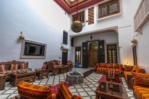 un ampio soggiorno con divani e TV di Dar Layali Fez a Fes