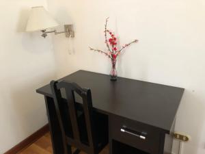 a black desk with a vase of flowers on it at Hotel de Turistas Abancay in Abancay