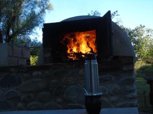 a brick oven with a fire in it at al otro lado del río in San Francisco del Monte de Oro