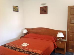 a bedroom with a red bed and two lamps at Cavern Apartments in Baie Sainte Anne
