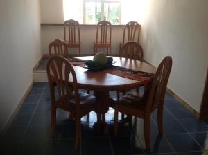a dining room table with chairs and a fruit on it at Cavern Apartments in Baie Sainte Anne