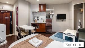 Cette petite chambre comprend un lit et une petite cuisine. dans l'établissement 玉出サクラハウスシングルルーム wifi付 玉出駅から徒歩2分 地下鉄難波迄8分, à Osaka