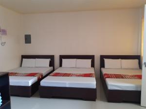 a room with two beds in a room at Veance Travellers Inn-Pabuas extension in Mambajao