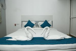 a bed with two swans made out of towels at The Base Inn (where convenience meets luxury) in Pondicherry