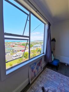 a room with a large window with a view at 180 degrees sea view 180度全海景房 in Oamaru