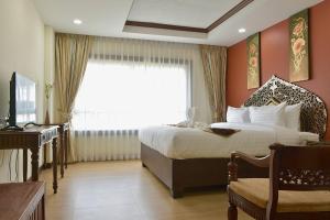 una camera con letto, scrivania e finestra di White Boutique Hotel and Spa a Chiang Mai