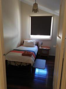 a small bedroom with a bed and a window at Woodlands of Balingup Bush Cottages -Flora & Fauna focused in Balingup