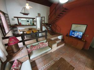 einen Blick über das Wohnzimmer mit einem TV in der Unterkunft Casa pé na areia em Toque Toque in São Sebastião
