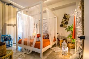 a bedroom with a canopy bed with orange sheets at Vinto House Salerno Downtown in Salerno