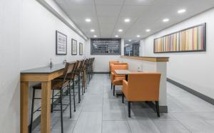 a dining room with orange chairs and a bar at Holiday Inn Express Hotel & Suites Charlottetown, an IHG Hotel in Charlottetown