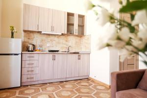 a kitchen with white cabinets and a refrigerator at Alba Hotel Yerevan in Yerevan