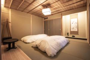 a bedroom with two beds and a table in it at 宿坊 観音院 Temple Hotel Kannonin in Kiryu +53 photos