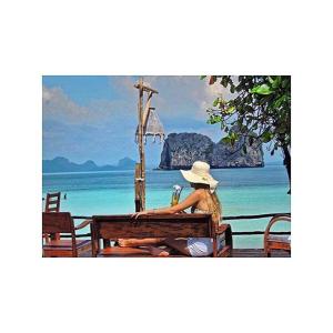 a woman sitting on a bench looking at the ocean at Thanya Beach Resort - SHA Plus in Ko Ngai
