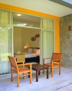 sypialnia z łóżkiem, 2 krzesłami i stołem w obiekcie Grand Udawalawe Safari Resort w mieście Udawalawe