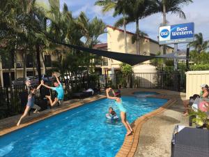 a man and a boy are playing in a pool at Best Western Airport 85 Motel in Brisbane