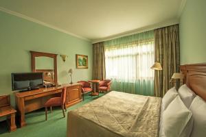a hotel room with a bed and a television at Grand Hotel Polyana in Estosadok