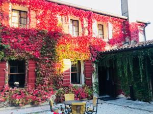 un edificio rosso con dei fiori sopra di I giardini segreti di Villa Marcello Marinelli a Cison di Valmarino
