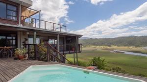 une maison avec une piscine sur une terrasse dans l'établissement Interlaken Guest House, à Wilderness