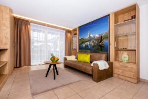 a living room with a couch and a large window at Apartment Aura in Zermatt