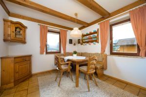 a dining room with a table and chairs and windows at Zur Oma Margret in Flachau