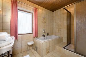 y baño con bañera y lavamanos. en Zur Oma Margret en Flachau