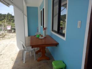 a small table and chairs in a room with a window at Jeno Tourist Inn in San Vicente