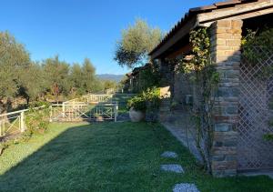 een tuin met een bakstenen gebouw en een hek bij Elaionas Zeliou in Nafpaktos