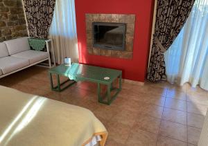a living room with a couch and a table and a tv at Elaionas Zeliou in Nafpaktos