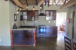 - une cuisine avec des placards en bois et un comptoir dans l'établissement Kwalata Bush Experience, Mabalingwe, à Mabula