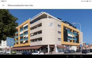 a large building with cars parked in a parking lot at Calle Austria in Roquetas de Mar