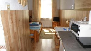 une cuisine avec une petite chambre avec un lit dans l'établissement Art-Mont, à Cracovie