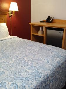 a bedroom with a bed and a desk with a phone at Econo Inn in Anchorage