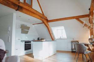 a kitchen with white walls and wooden beams at "REH"-sidenz Moselschleife in Leiwen