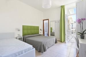 a bedroom with two beds and a green headboard at Hotel Nuovo Tirreno in Lido di Camaiore