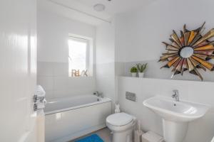 Baño blanco con lavabo y aseo en Lakeside Palace en West Thurrock
