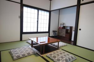 a living room with a table and two ottomans at Yamaguchi House Annex, Private House with Onsen in Hakone