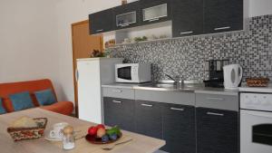 una pequeña cocina con mesa y microondas en Apartmani Nena, en Slano