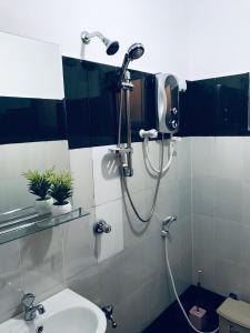 een douche in een badkamer met een wastafel bij Seabreeze Apartment in Galle