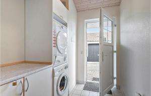 a laundry room with a washing machine and a window at Marina Fiskens Feriepark in Gråsten