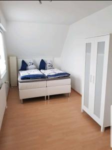 sypialnia z łóżkiem z niebieskimi poduszkami w obiekcie Ferienwohnung Heuer w mieście Fehmarn