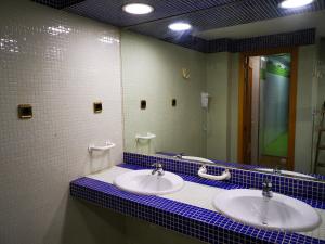 a bathroom with two sinks and a mirror at Hostal Quinta Santillan in San Fernando de Henares