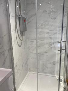 a shower with a glass door in a bathroom at Brownlows Inn Rooms formerly Riley's Rooms in Liverpool